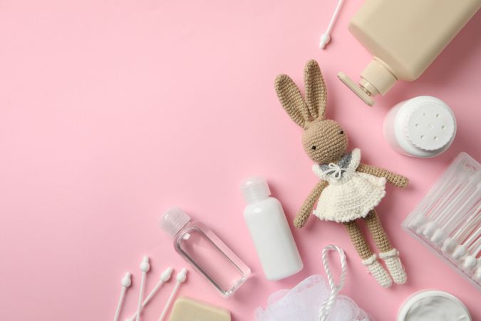 Baby hygiene accessories on pink background, top view