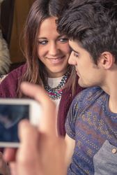 Man hands taking photos to couple on sofa