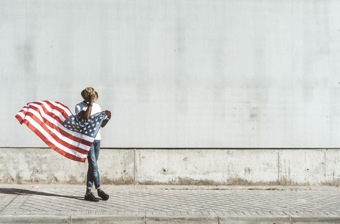Happy black man with flying American flag