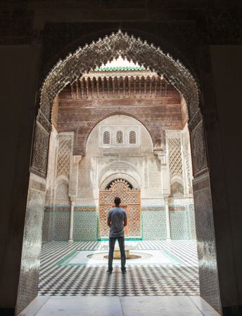 Man in blue jacket standing in Al Attarine Madrasa