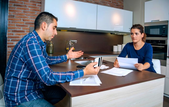 Man and woman having tense discussion over bills