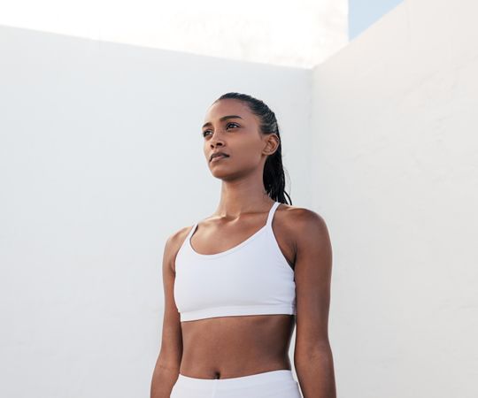 Slim confident sportswoman relaxing standing tall before exercising