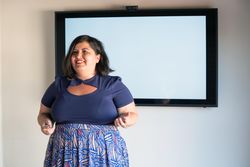 Happy woman public speaking in front of screen