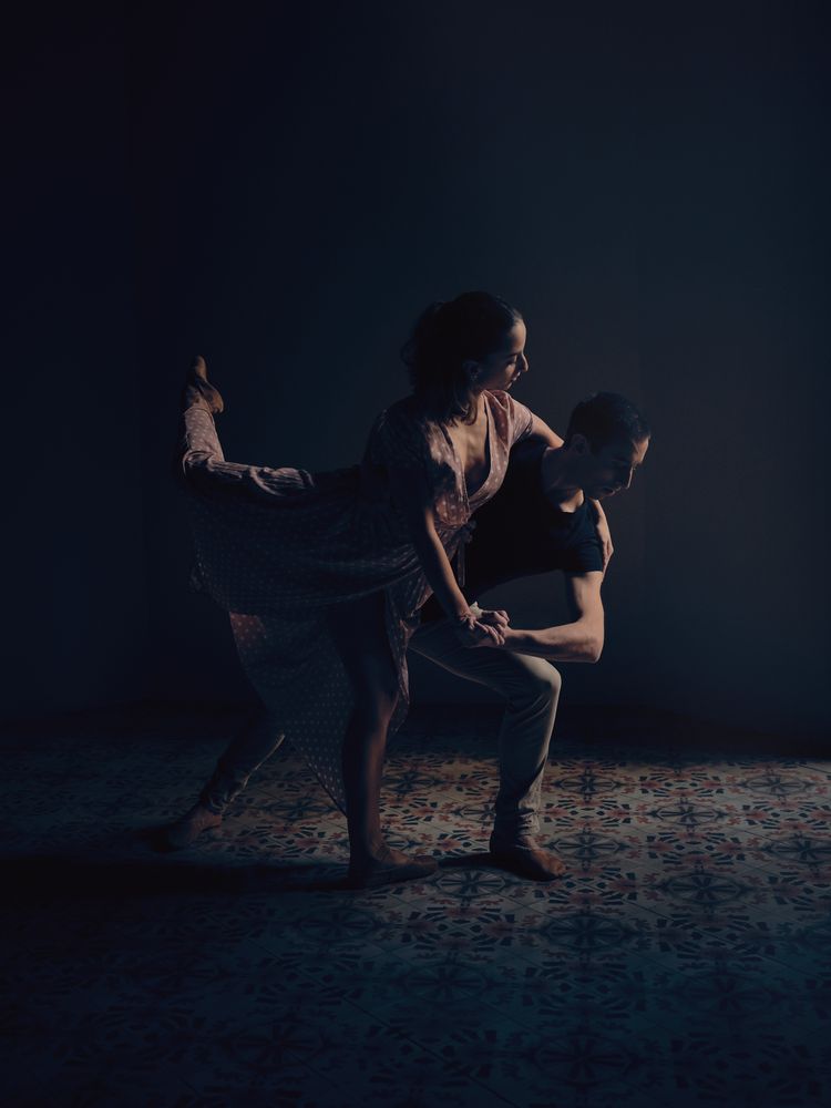 Ballet dancers performing dance in dark studio