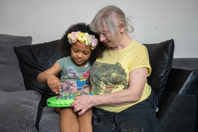 Older woman and grandchild on coach at home