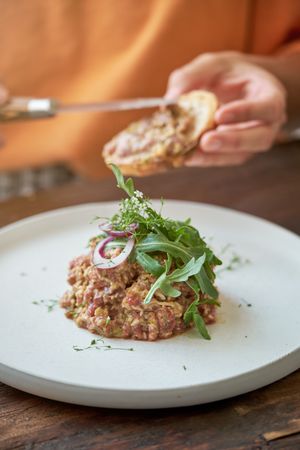 Crop person having lunch in kitchen