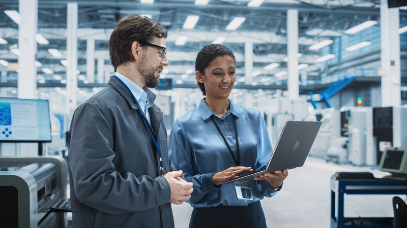 Colleagues talking in store over laptop