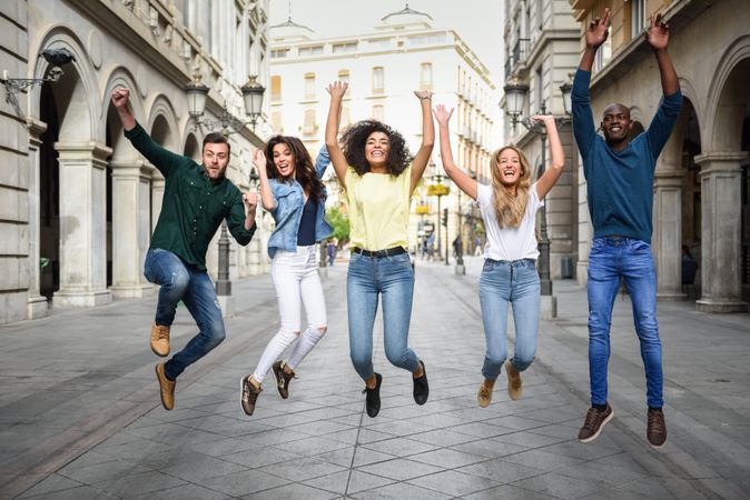 Group of people jumping together in European city street