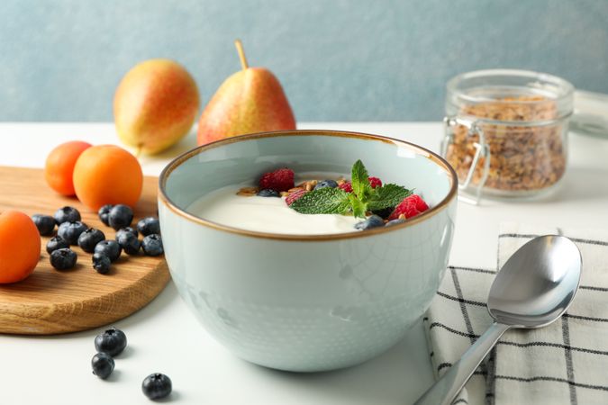 Composition with yogurt dessert and ingredients on neutral background, space for text