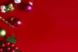 Red Christmas background with Christmas decorations, holly and ornaments.