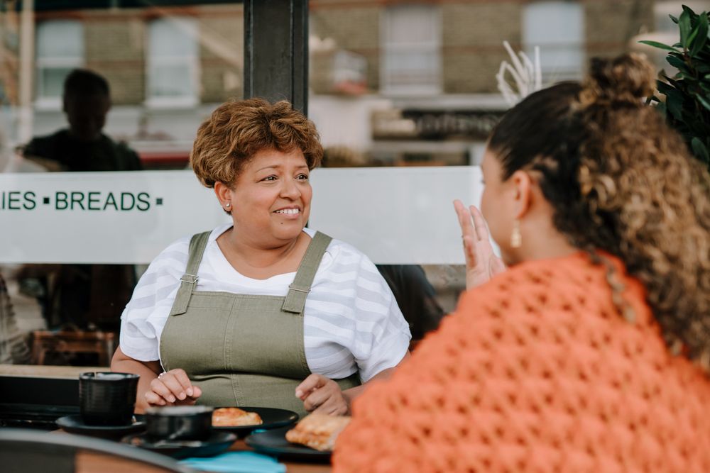 Mother and daughter talking over lunch at restaurant