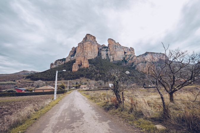 Rural road to majestic cliff on gloomy day