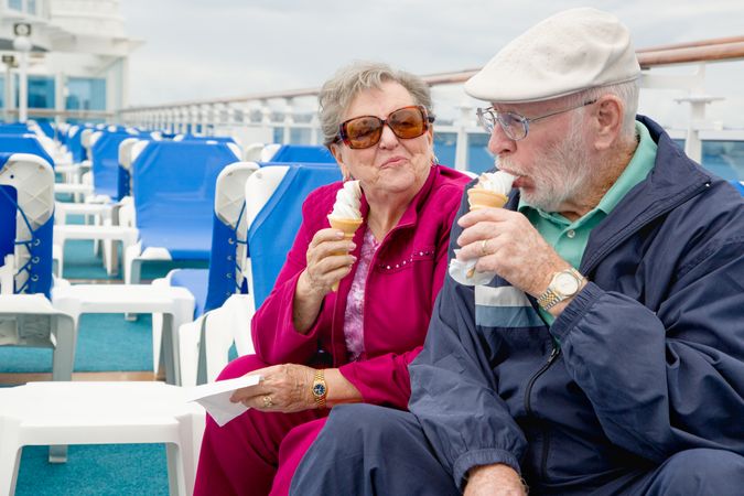 Content Happy Adult Couple Enjoying Ice Cream On The Deck of a Luxury Passenger Cruise Ship.