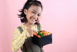 Asian Girl Showing Her Homemade Healthy Lunchbox with Happy Expression