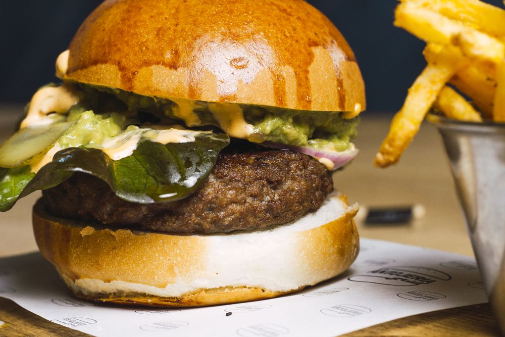Juicy delicious burger and fried potato on table