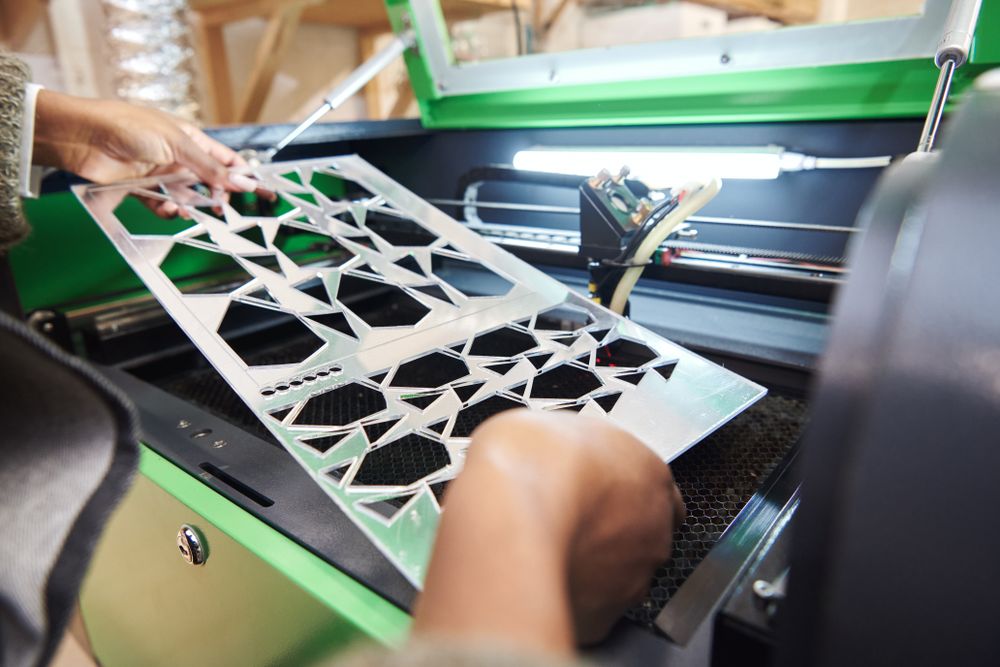 Close up of hands working at laser cutter machine