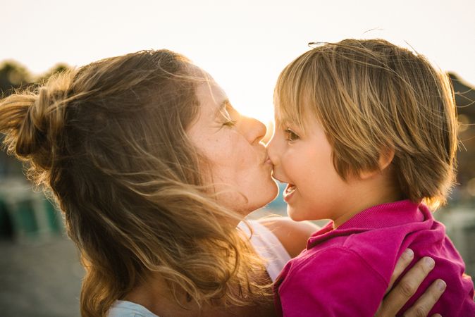 Woman with naughty boy on hands on beach