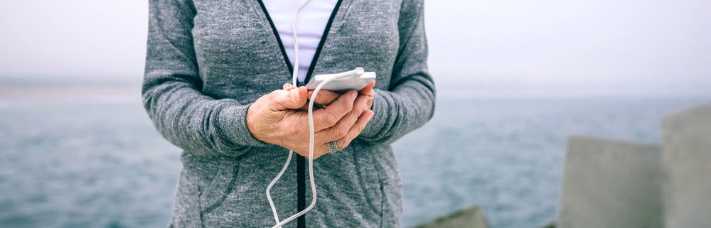 Mature sportswoman holding her smartphone