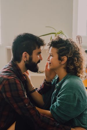 Loving couple embracing while sitting on apartment floor