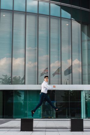 Man jumping on pavement of highrise