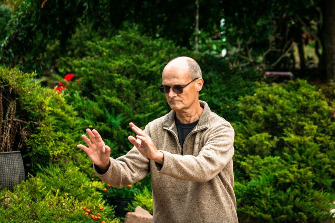 Older man practicing martial arts in countryside