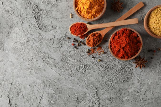 Wooden bowls with red, yellow and brown spices, with copy space