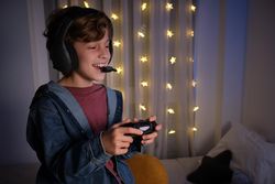 Positive boy in headphones playing videogame