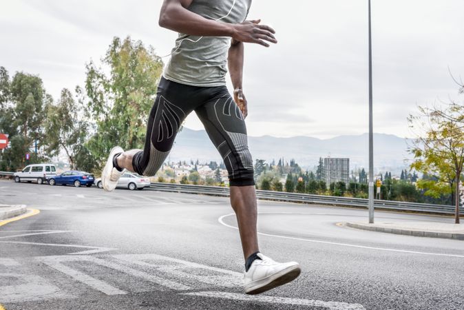Body of male running on city street
