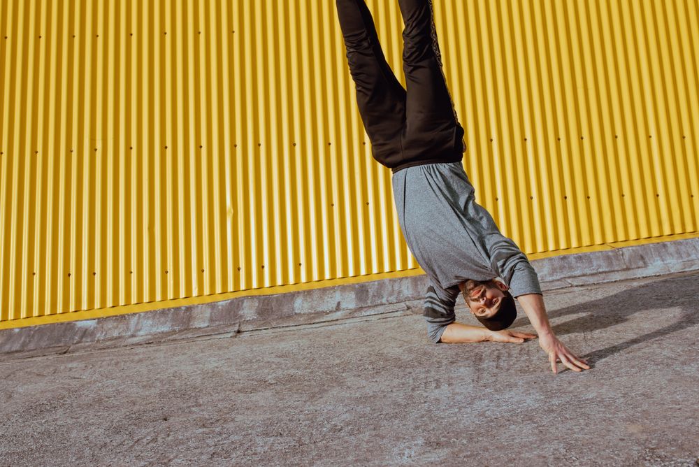 Man performing handstand near wall