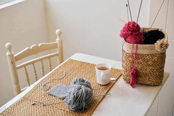 Mug of tea near knitting supplies