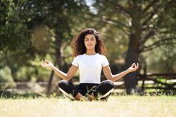 Arab woman doing yoga in field