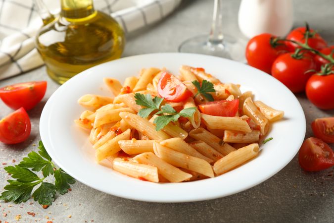Composition with plate of tasty pasta on gray background, close up