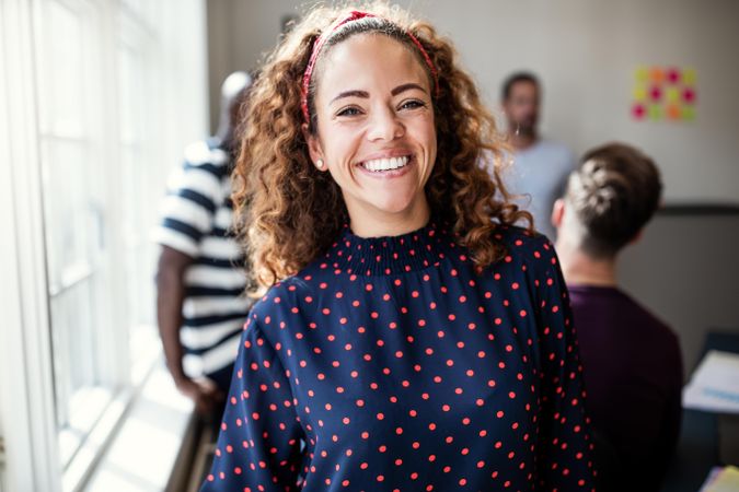 Woman with curly hair smiling in an office