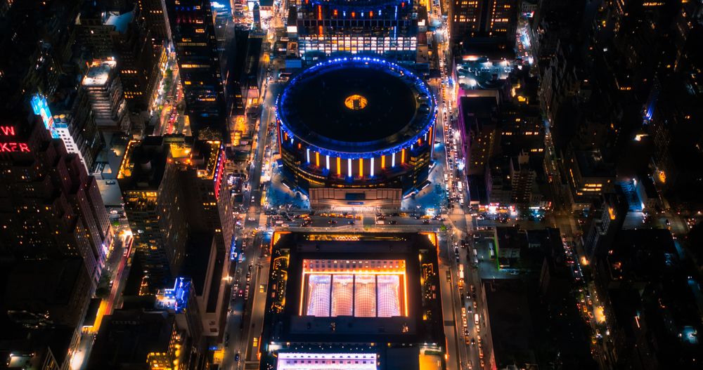 Helicopter Tour of New York City Architecture at Night. Midtown Manhattan Office Buildings and Skyscrapers. Aerial Urban Landscape with Lights in the Evening