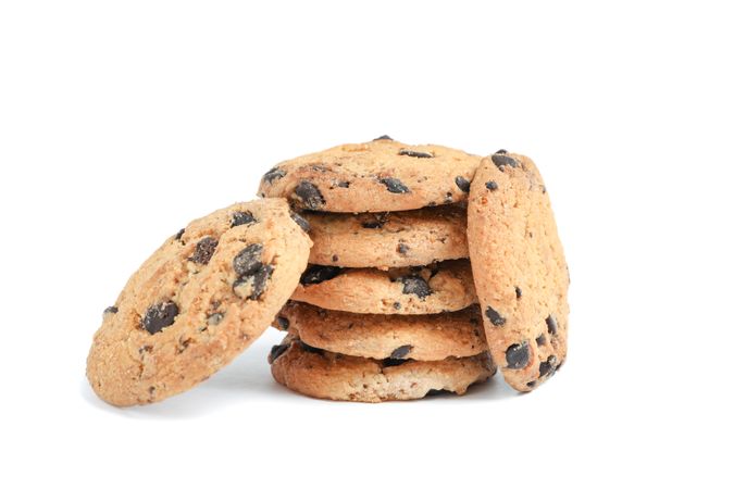Stack of tasty chocolate chip cookies on plain background