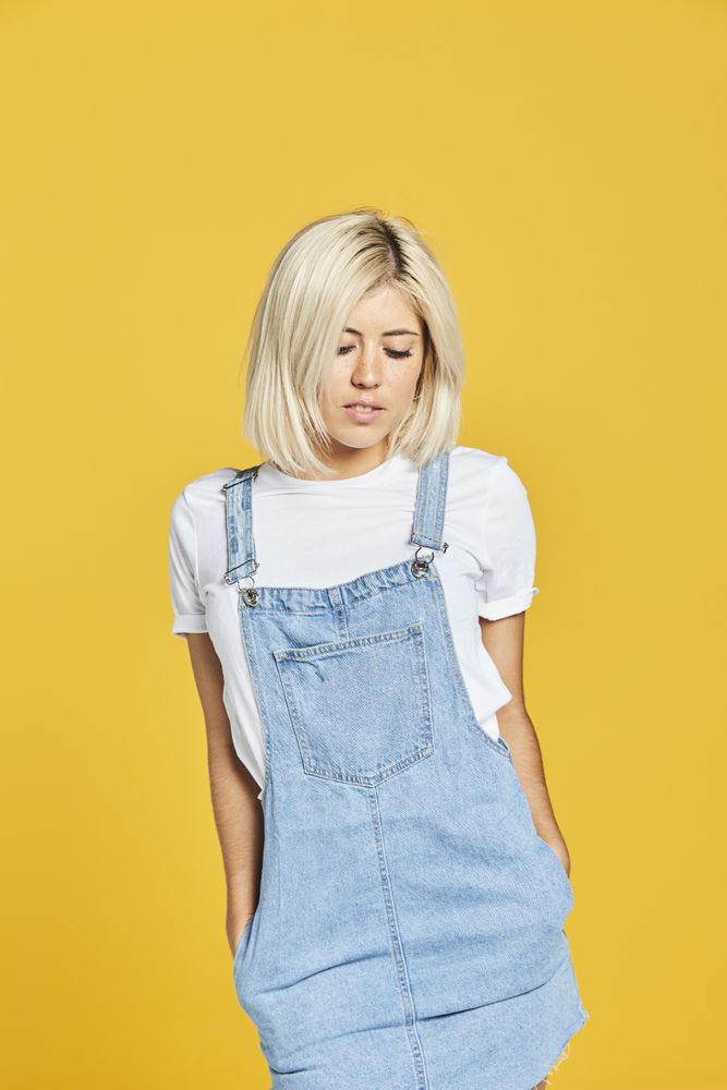Trendy blonde female in denim sundress