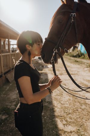Woman kissing horse on ranch