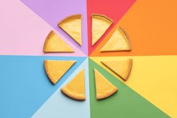 Sliced cheesecake on a rainbow background