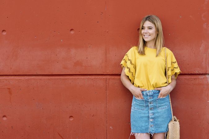 Cheerful woman standing on orange background