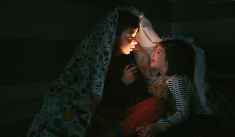 Boy telling a story of fear to his sister
