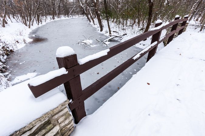 Rustic Bridge Over Frozen River In Winter.