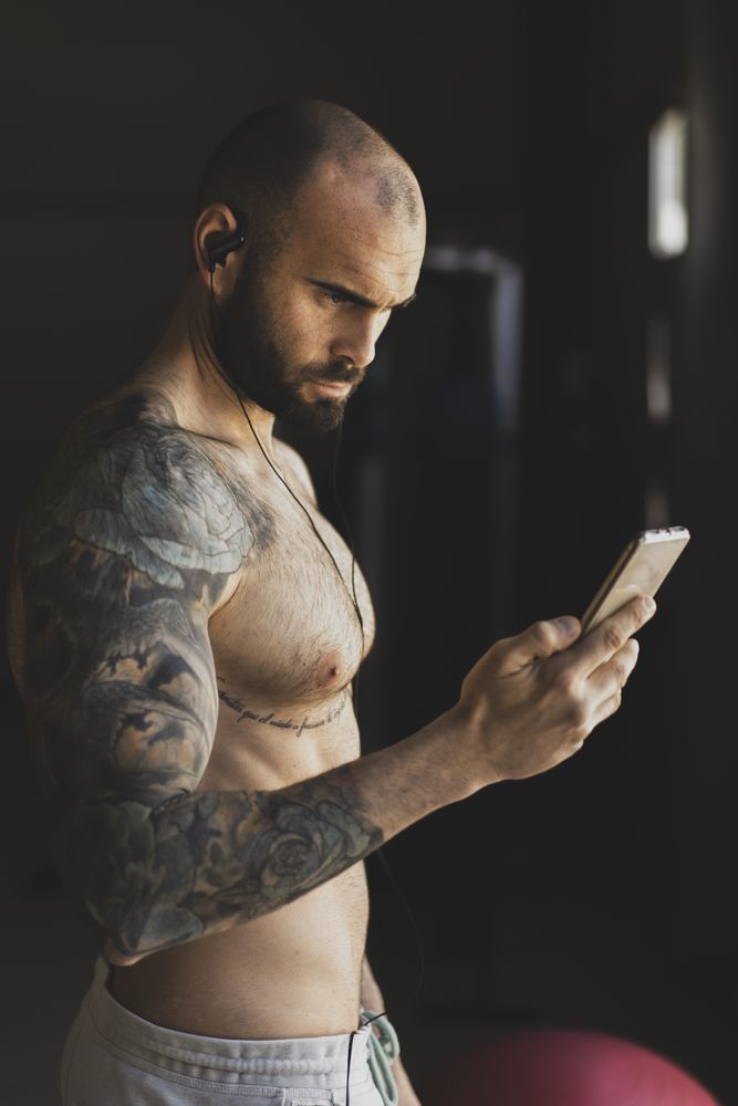 Athlete with smartphone in gym