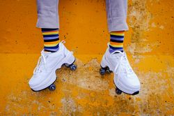 Unrecognizable person wearing sneakers with wheels and rainbow socks