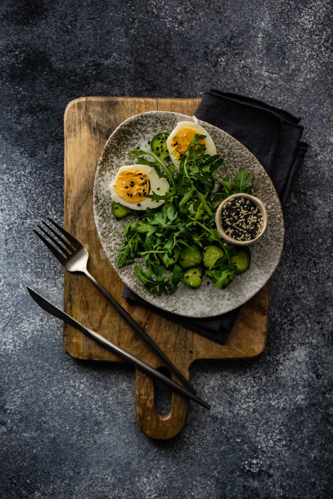 Top view of healthy salad with hard boiled egg, cucumber with lemon slices