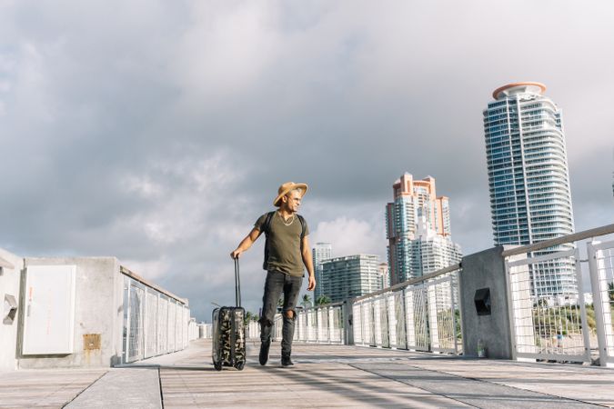 Traveller hipster man wearing a hat With A Suitcase