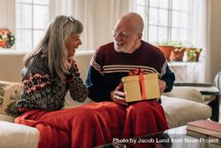 Older man giving a Christmas gift to his wife 41p375