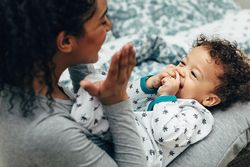 Smiling mother clapping and playing with son