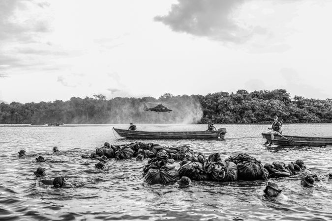 Grayscale photo of people on boats on water