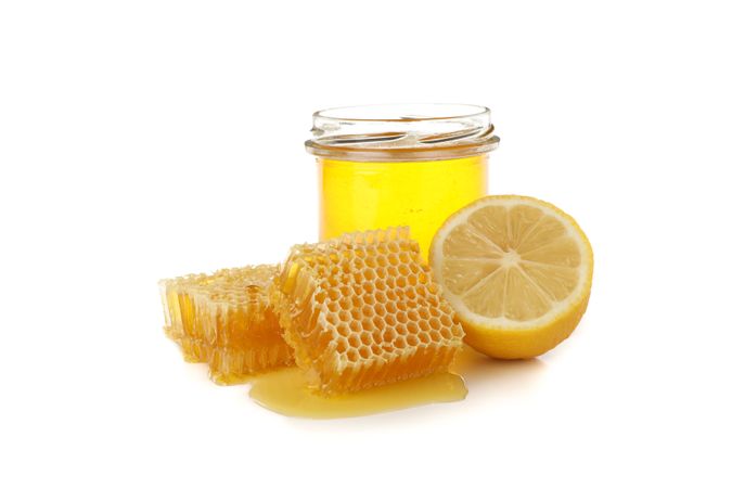 Pieces of honeycomb, glass jar and lemon isolated on neutral background