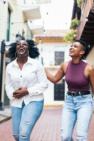 Black women laughing and having fun walking in the city
